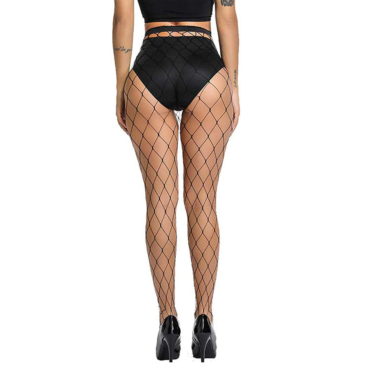 A woman stands with her hands down by her side. She is wearing some black lingerie, high heels and net tights.